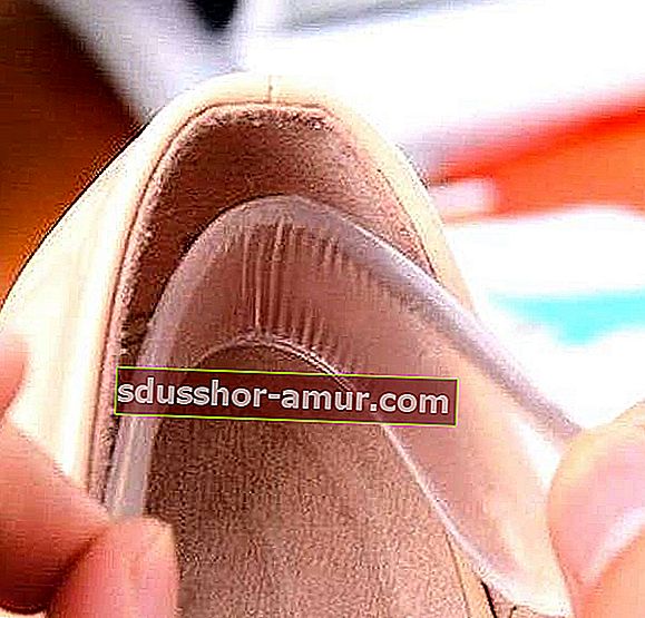 Руки, вставляющие силиконовую подушечку внутрь обуви.