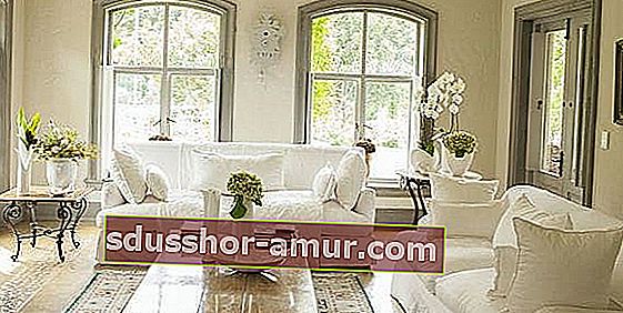 Гостиная наполнена белой мебелью с простым видом