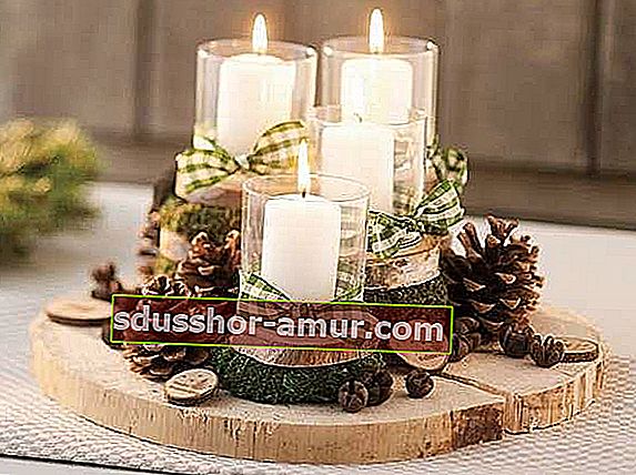 Leseni hlodi na sredini mize z več svečami zgoraj