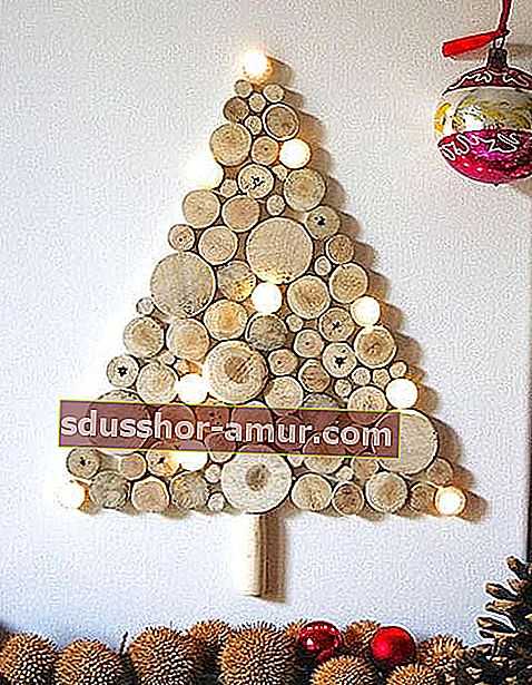 Božično drevo iz lesenih hlodov in osvetljenih venci