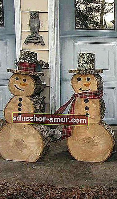 Два снеговика на открытом воздухе из деревянных бревен 