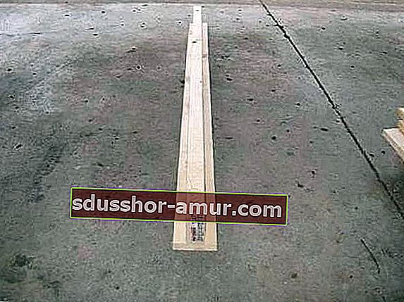 2 leseni deski, sestavljeni v obliki črke T, na betonskem tleh.