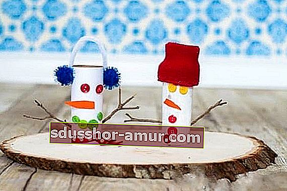 Snežak iz zvitkov toaletnega papirja, prilepljenih na okrasno leseno desko