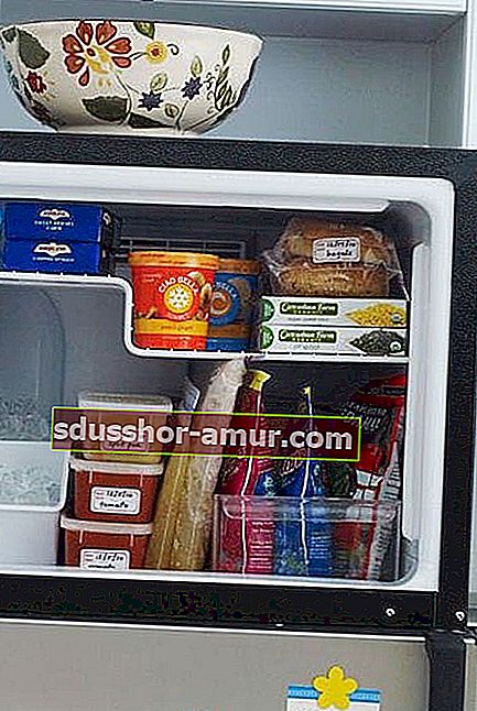 Več živil, shranjenih v zamrzovalniku v različnih zabojnikih 