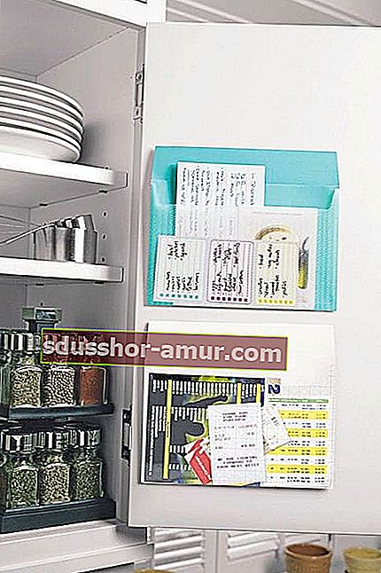 Белый кухонный шкаф с местом для хранения на двери списков покупок и бумаг.