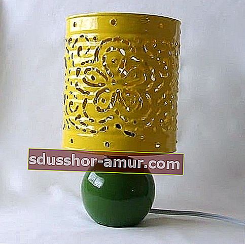 Pločevinka, okrašena in razrezana v rumeno, da tvori svetilko 