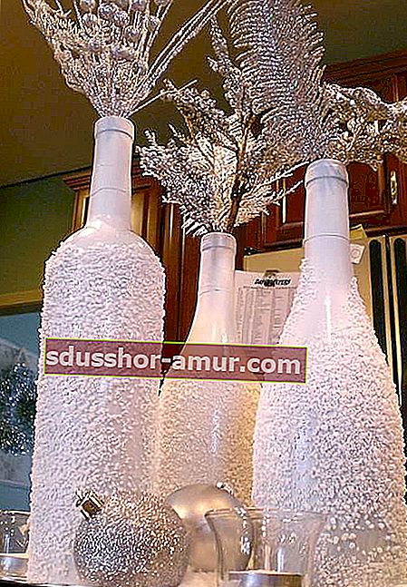 Tri steklenice vina z zimsko dekoracijo
