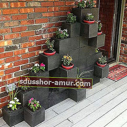 бетонные блоки выкрашены в черный цвет и превращены в цветочные горшки