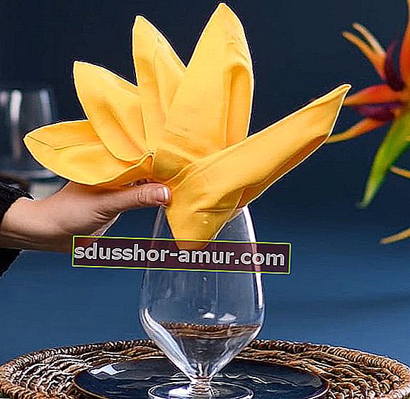 Žuta salveta složena u rajsku pticu na čaši 