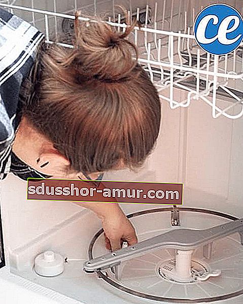 Žena čisti filtre perilice posuđa.