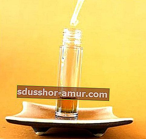 Капкомер, който налива етерични масла в бутилка, за да направи серум против бръчки.