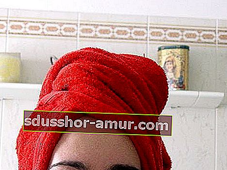 Красное полотенце на голове после мытья волос