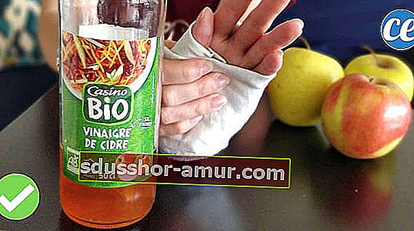 Бутылка яблочного уксуса и перевязанная рука для снятия боли в суставах