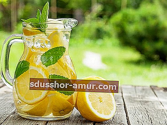 Vrč vode s limunom na drvenom stolu za mršavljenje