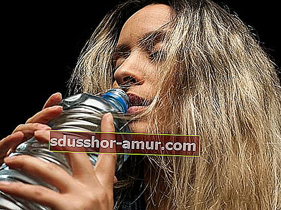 Ženska pije vodo iz steklenice