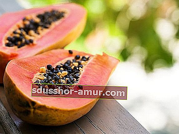 Нарязана наполовина папая на дървена маса за диета