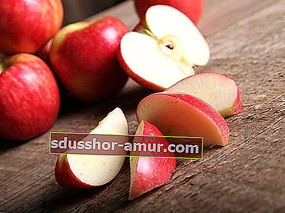 Crvene jabuke na izrezanom drvenom stolu