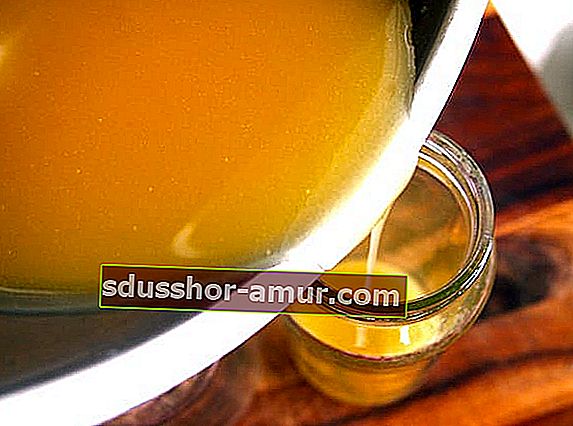 Stopljeni med, olje sladkega mandlja in čebelji vosek vlijemo v steklen kozarec za domačo vlažilno kremo.
