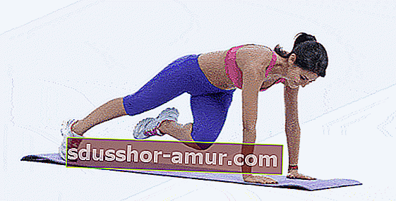 Žena koja vježba penjačice sa rotacijom kukova kako bi imala ravan trbuh.