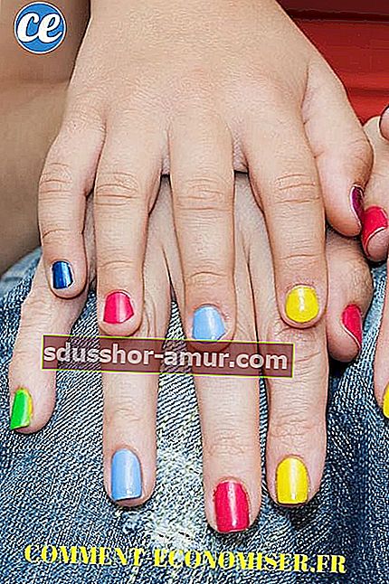 Женские руки с разноцветным маникюром.