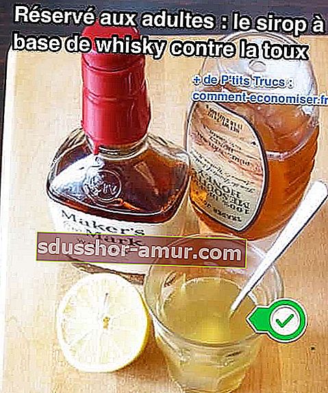Бутилка уиски и мед и половин лимон се поставят до чаша, съдържаща лекарството